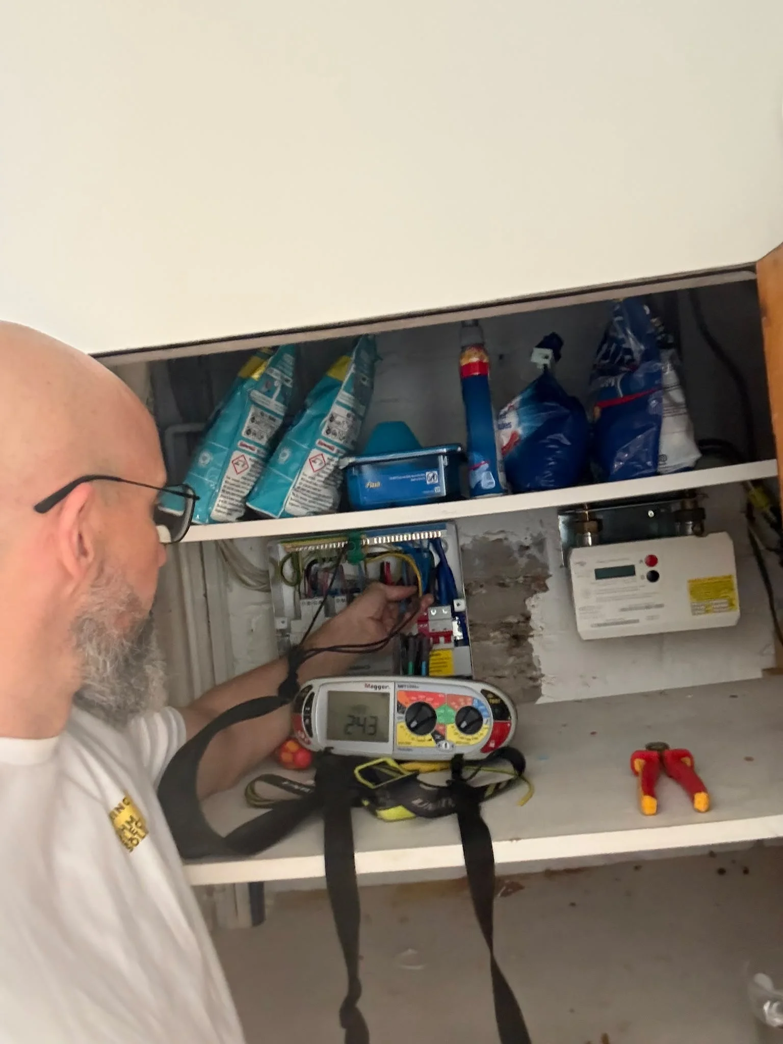 Electrician recording details beside an open consumer unit