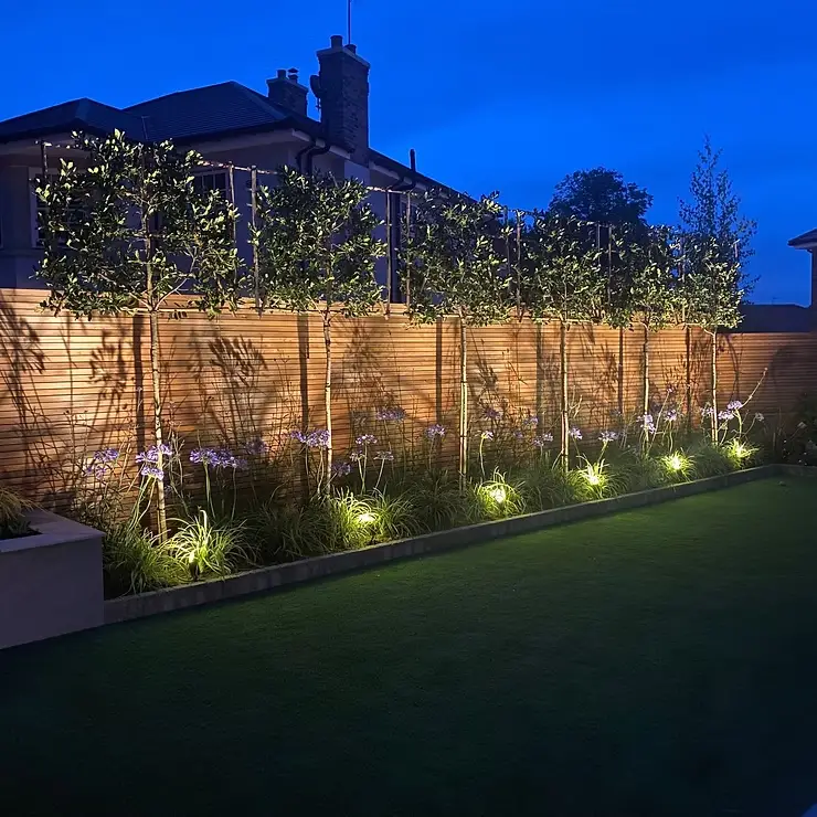 Stylish garden lighting next to shrubbery